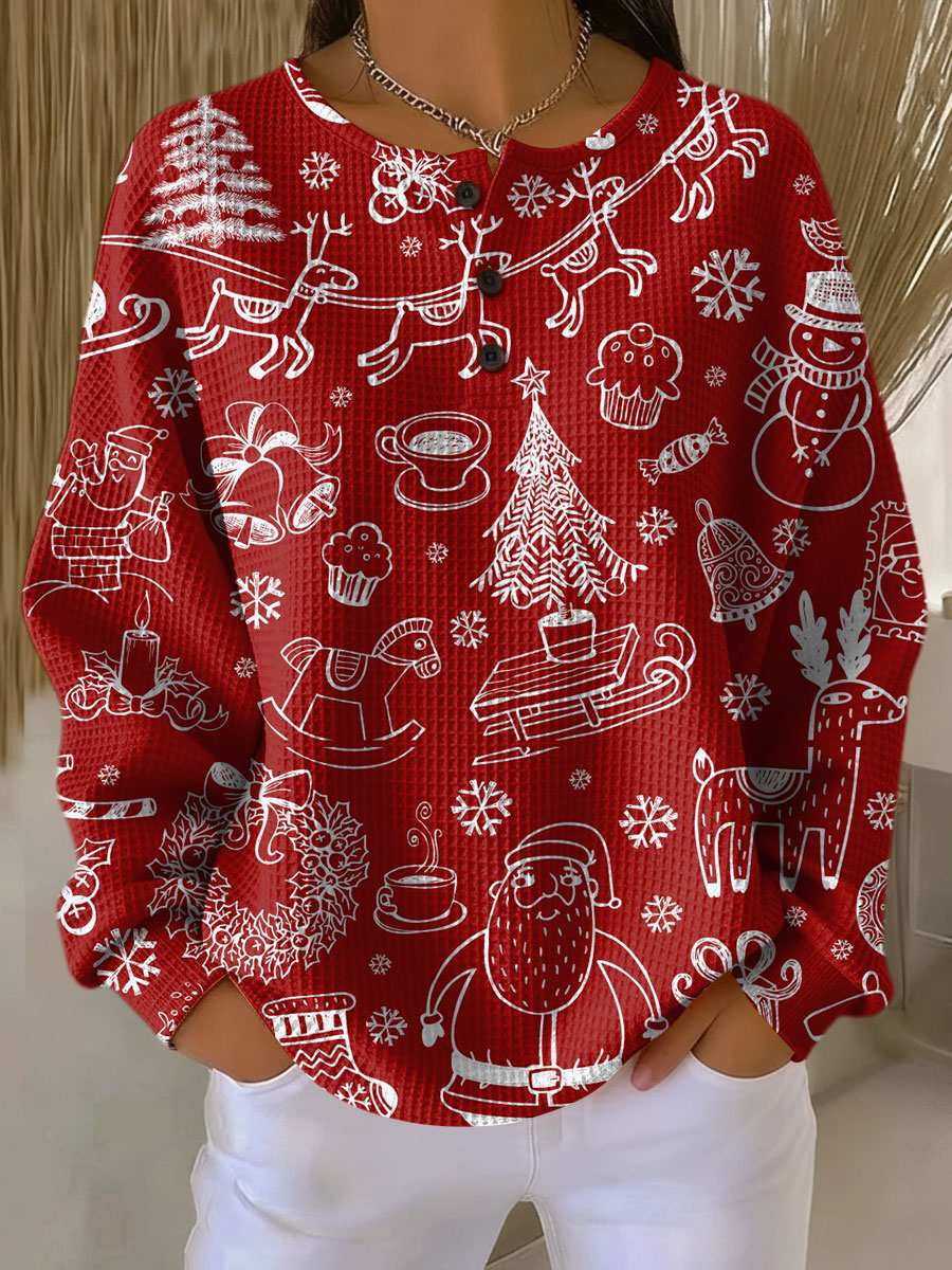 Červený vaflový svetr s knoflíky u výstřihu a bílým vánočním potiskem Santy, soba, stromků a zvonků, nošený s bílými kalhotami. 21
