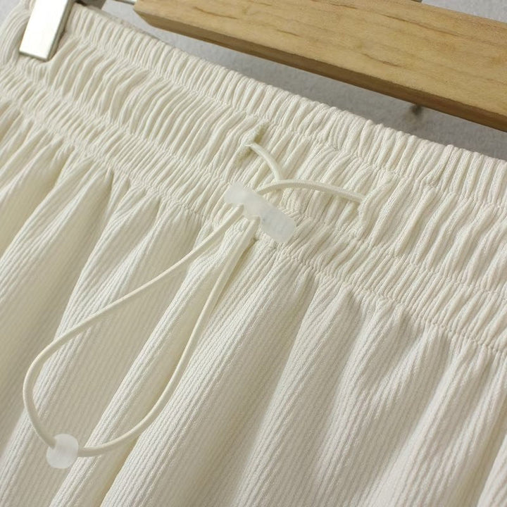 Weiße Baumwollhose mit Kordelzug, geripptes Design, lässige Damenmode, Nahaufnahme.