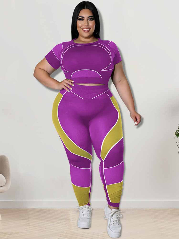 Frau in lila-gelbem Sportanzug, Plus-Size, lächelt, steht vor weißer Wand, modisch, bequem.