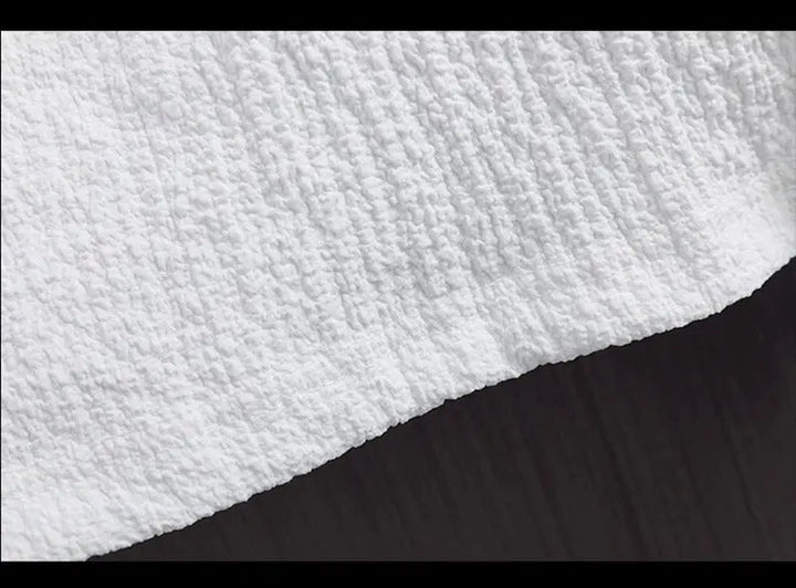 Weiße, strukturierte Stoffoberfläche, Nahaufnahme, Textil, Baumwolle, Heimtextilien, Detailansicht.
