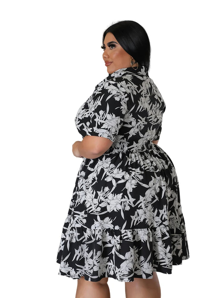 Frau in schwarz-weißem Blumenkleid, Plus-Size, Kurzarm, Rückansicht, Mode für Damen.
