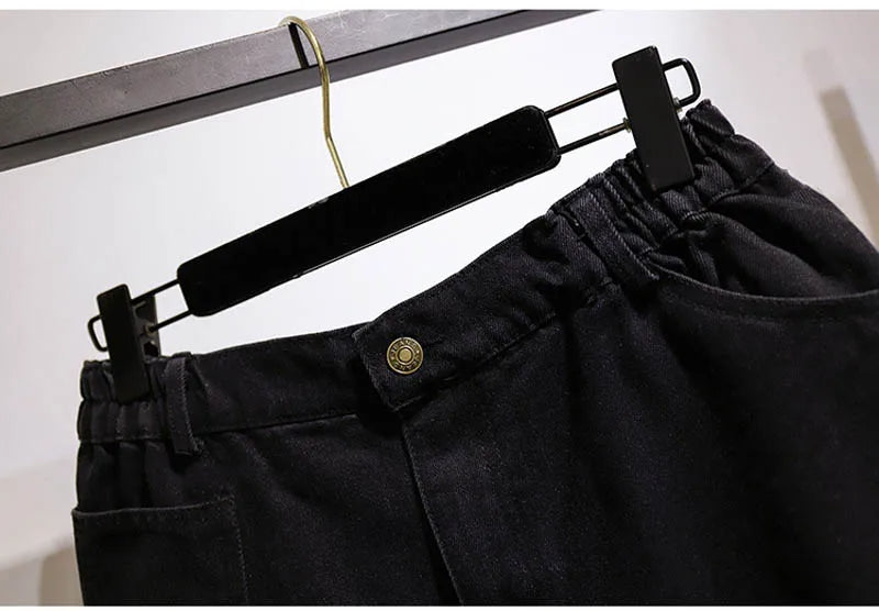 Schwarze Jeanshose mit elastischem Bund, Knopfverschluss, auf Kleiderbügel, modisch, bequem.