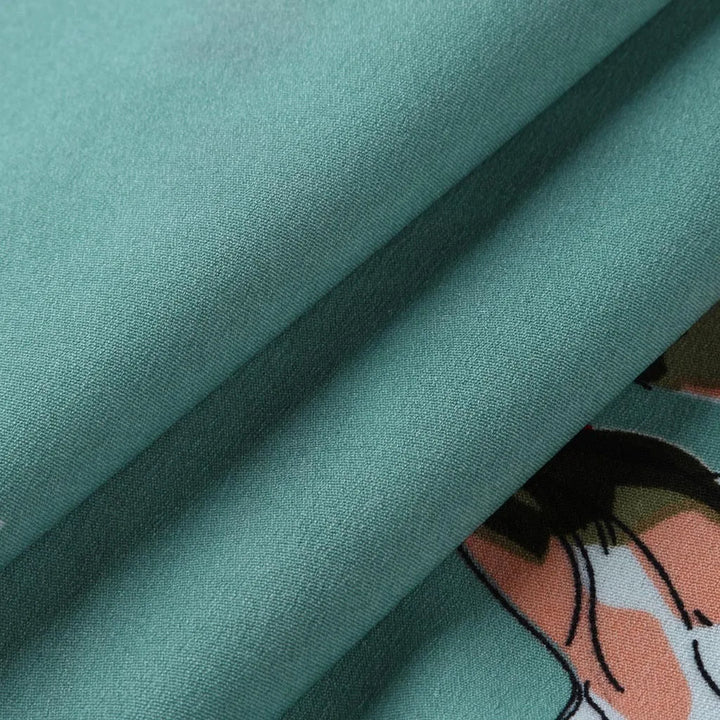 Grüner Baumwollstoff mit floralem Muster, ideal für Bekleidung und Heimtextilien.