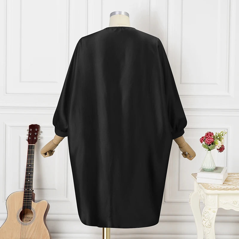 Schwarzes Satinkleid auf Schneiderpuppe, elegantes Design, langärmlig, modisch, Damenmode.