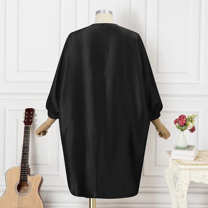 Schwarzes Satinkleid auf Schneiderpuppe, elegantes Design, langärmlig, modisch, Damenmode.