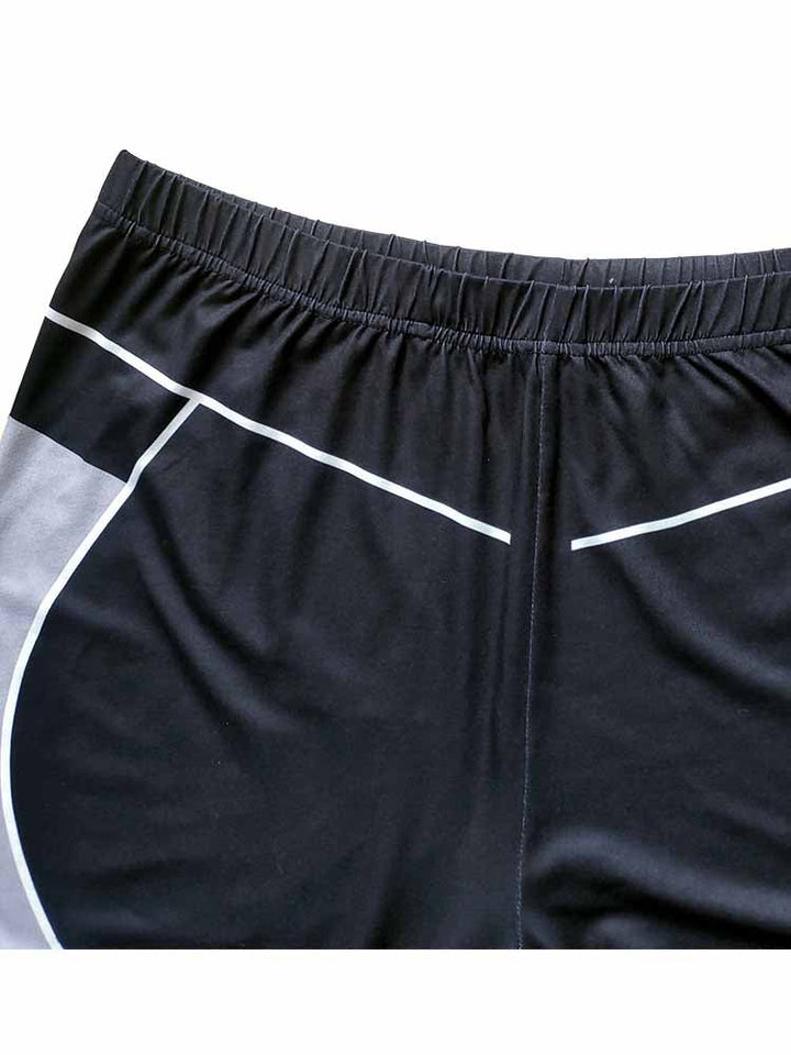 Schwarze Sportshorts mit weißen Streifen, elastischer Bund, atmungsaktives Material.