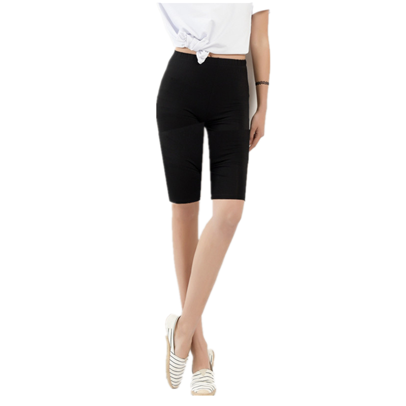Frau in schwarzer Radlerhose und weißem T-Shirt, modische Sommerkleidung, Freizeitlook.