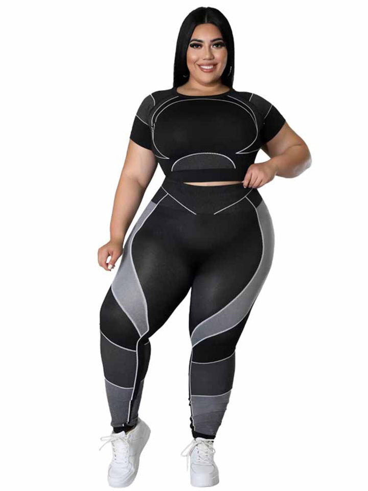 Frau in schwarzem Sport-Set mit grauen Akzenten, Plus-Size, Fitnessmode, lächelnd.