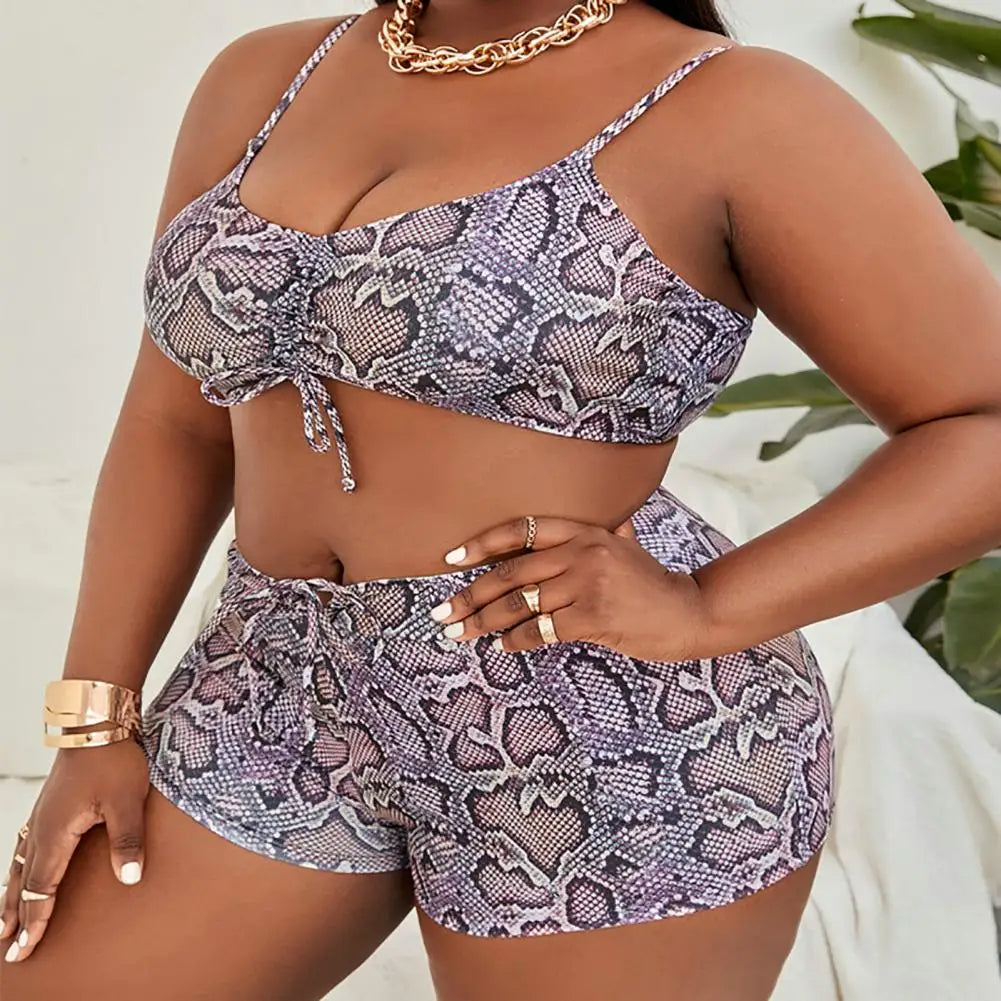 Frau in Schlangenprint-Bikini-Set, lila, mit Goldschmuck, Sommermode, Plus-Size-Bademode.