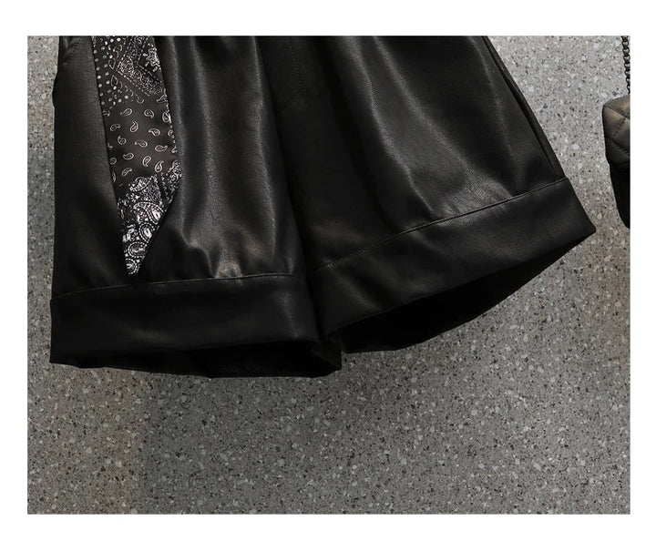 Schwarzer Lederrock mit Paisley-Muster, elegantes Design, Damenmode, Detailansicht.