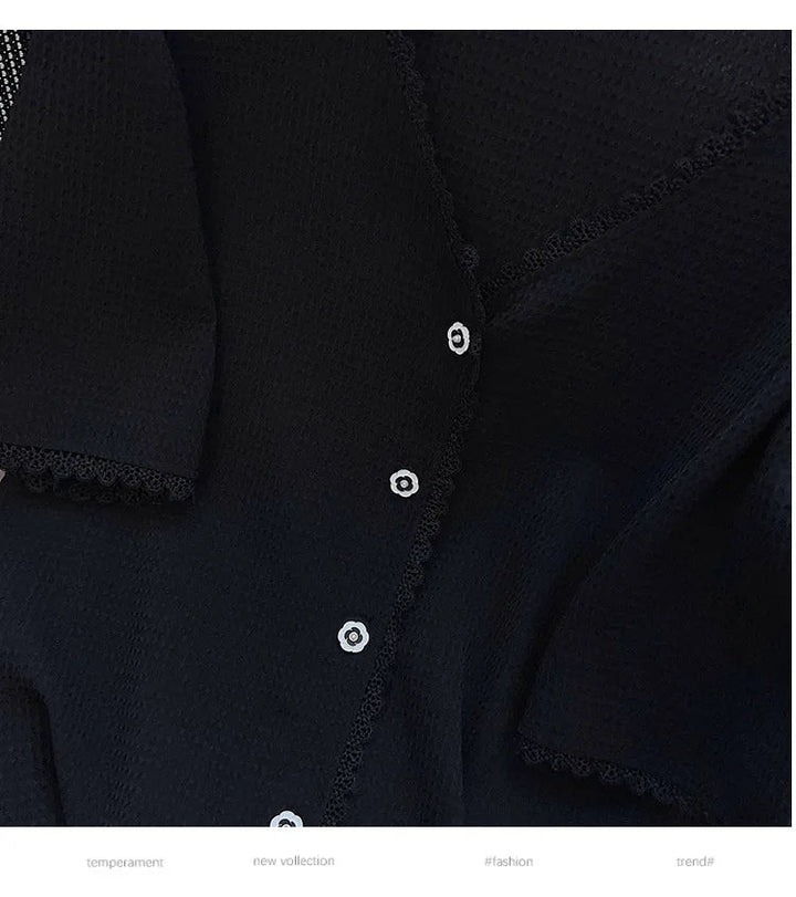 Schwarze Damenbluse mit Spitzenbesatz und weißen Knöpfen, elegante Mode, neue Kollektion.