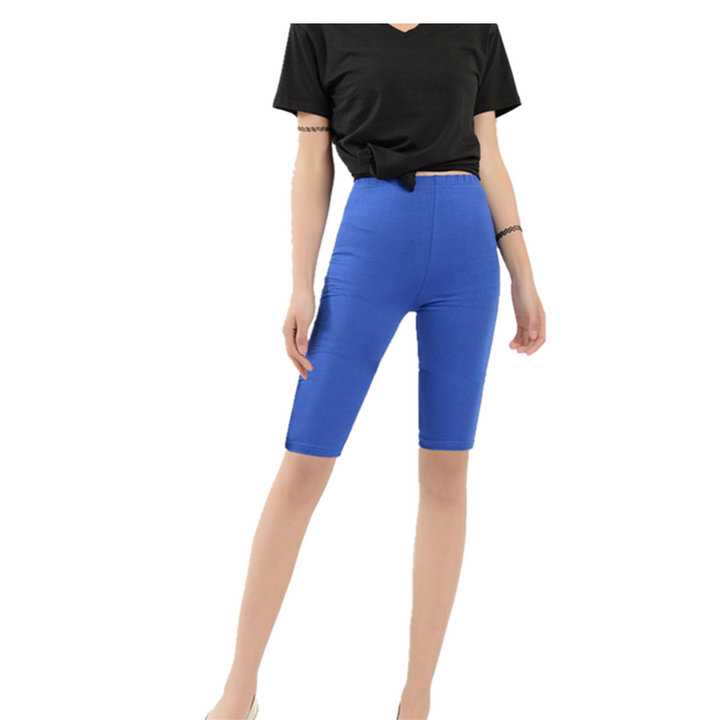 Frau in schwarzem T-Shirt und blauer Radlerhose, sportlich, bequem, modisch.