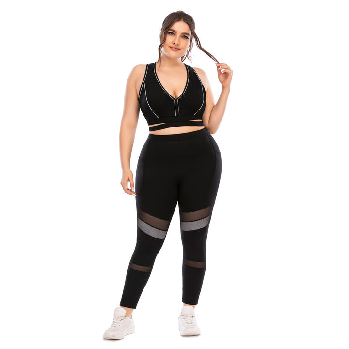 Frau in schwarzem Sport-BH und Leggings mit Mesh-Einsätzen, Fitnessmode, Plus-Size.