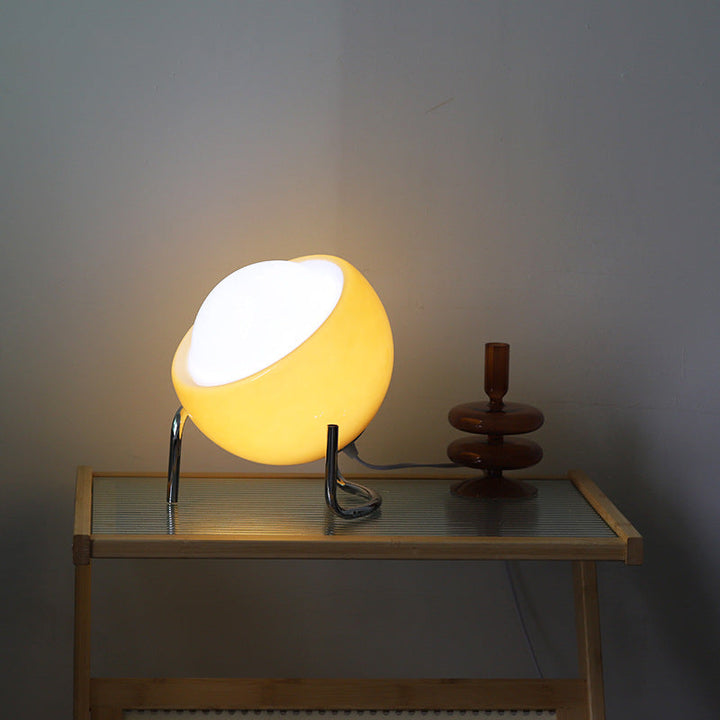Gelbe Tischlampe aus Glas auf Holztisch, modernes Design, Wohnzimmerbeleuchtung.