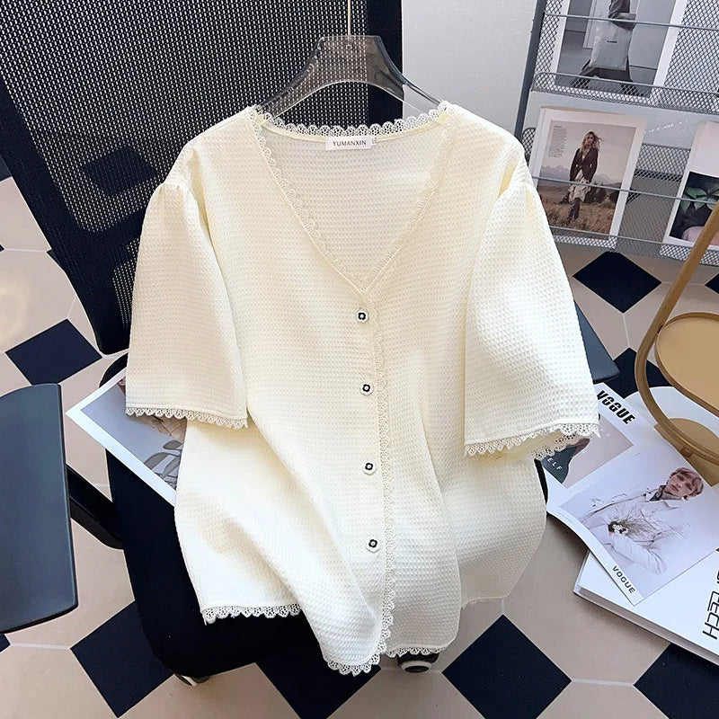 Weiße Strickjacke mit Knöpfen, V-Ausschnitt, Spitzenbesatz, Damenmode, elegant, auf Stuhl.