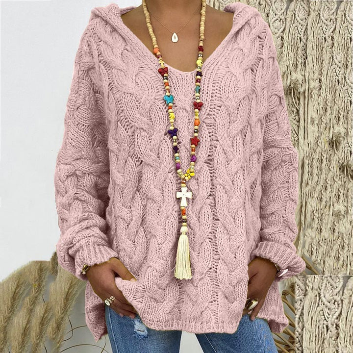 Frau in rosa Strickpullover mit Zopfmuster, bunte Halskette, lässiger Stil, Herbstmode.