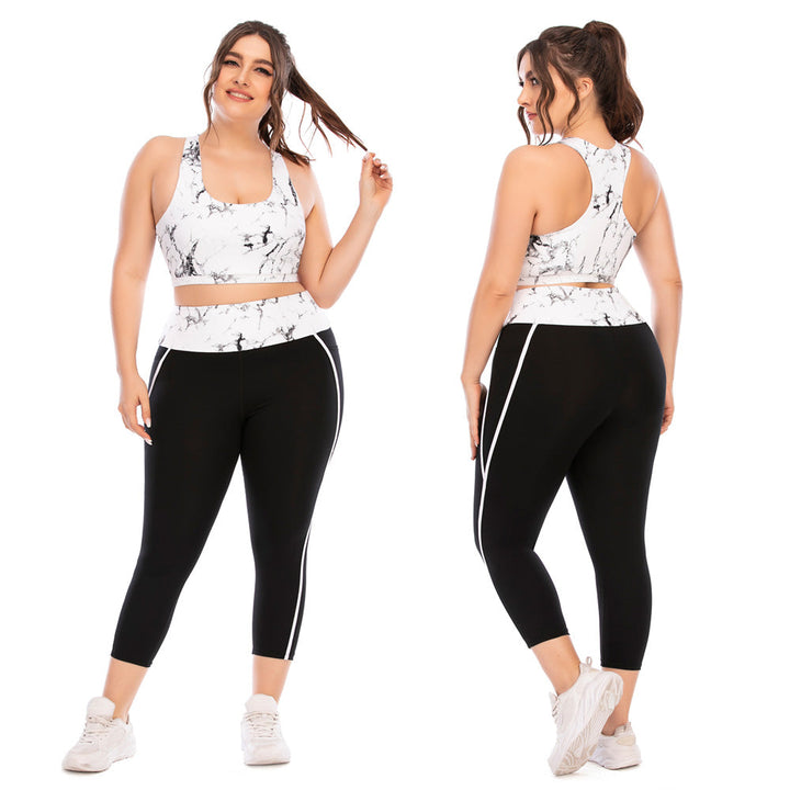 Frau in Sportbekleidung, weißes Marmor-Top, schwarze Leggings, Plus-Size, Fitnessmode.