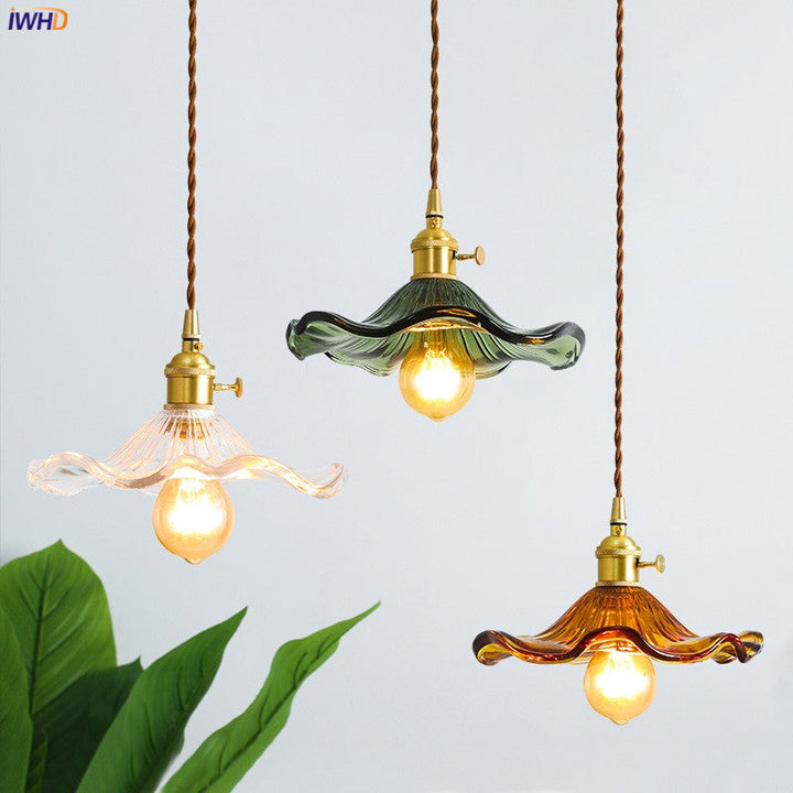 Drei Vintage-Pendelleuchten aus Glas in Grün, Bernstein und Klar mit Edison-Glühbirnen.
