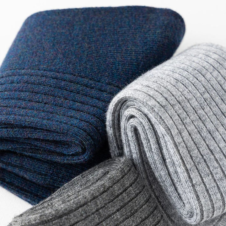 Drei gefaltete Wollschals in Blau, Hellgrau und Dunkelgrau, gestrickt, warm, modisch.