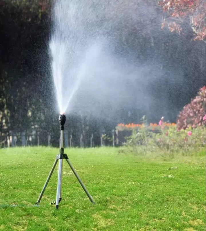 Rasensprenger auf Stativ im Garten, bewässert Rasen, Sommer, effizient, einstellbar.
