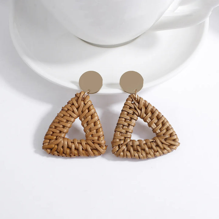 Dreieckige Ohrringe aus geflochtenem Rattan, goldene Details, modisches Accessoire.