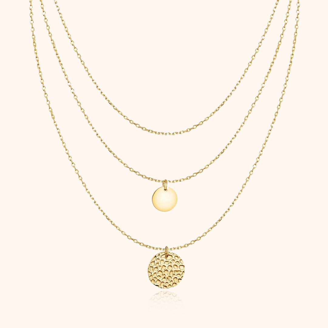Goldene Halskette mit drei Anhängern, runde Plättchen, elegantes Schmuckdesign, Damenaccessoire.