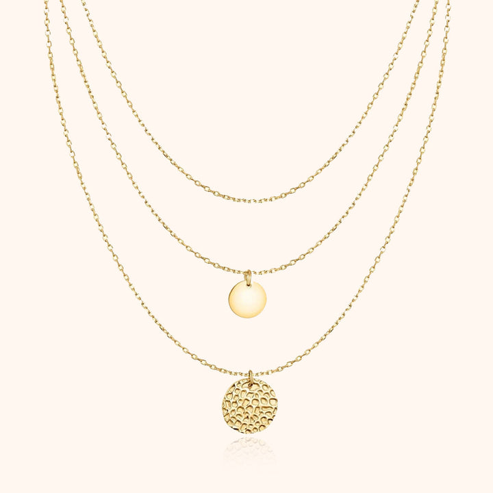 Goldene Halskette mit drei Anhängern, runde Plättchen, elegantes Schmuckdesign, Damenaccessoire.