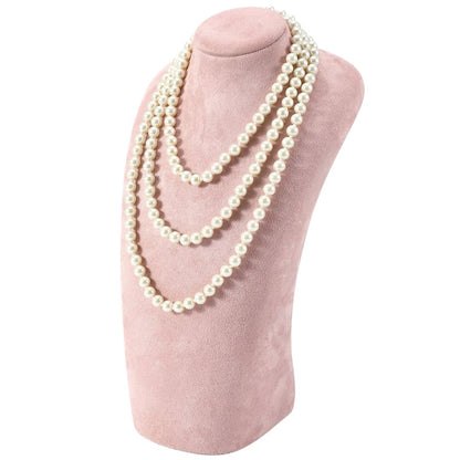 Perlenkette auf rosa Samt-Büste, eleganter Schmuck, dreireihig, klassisch, zeitloses Design.