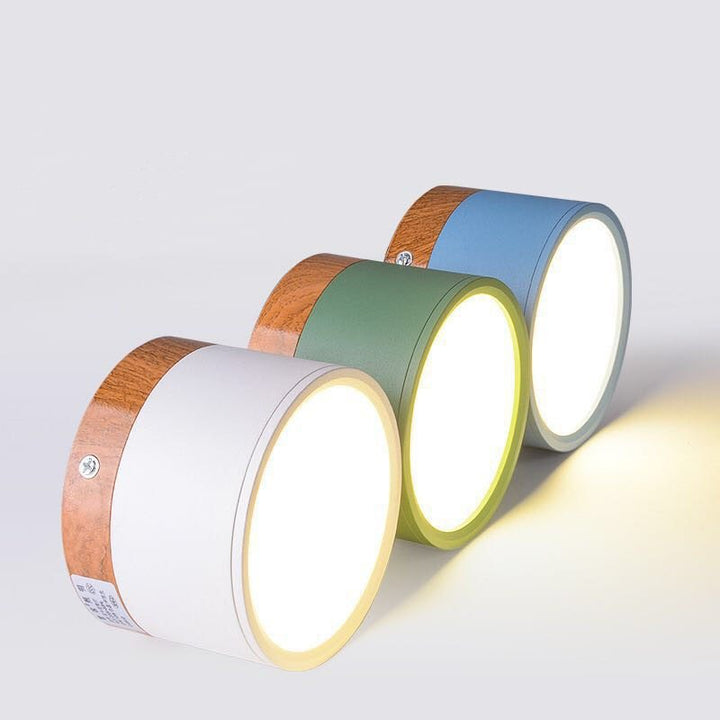 Drei runde LED-Wandleuchten aus Holz in Weiß, Grün und Blau, modernes Design.
