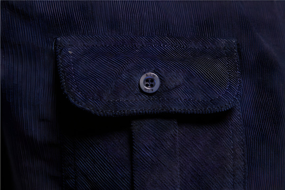 Dunkelblaue Jackentasche mit Knopf, Cordstoff, modisches Design, Detailaufnahme.