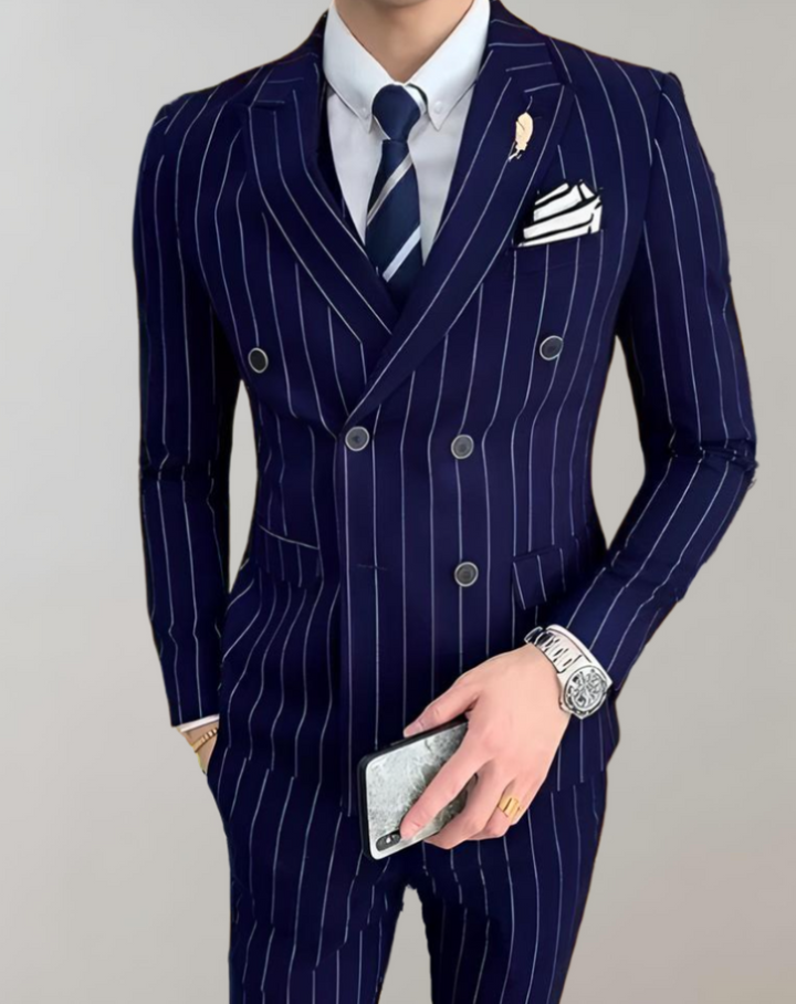 Mann im dunkelblauen Nadelstreifenanzug mit Krawatte, Uhr und Handy, elegantes Herrenoutfit.
