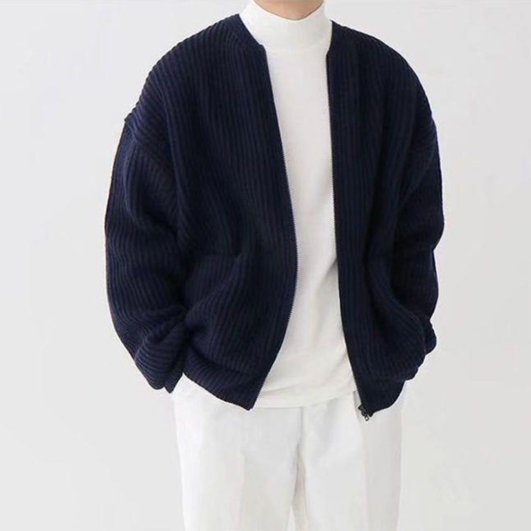 Dunkelblaue Strickjacke für Herren, gerippt, lässig, über weißem Rollkragenpullover.