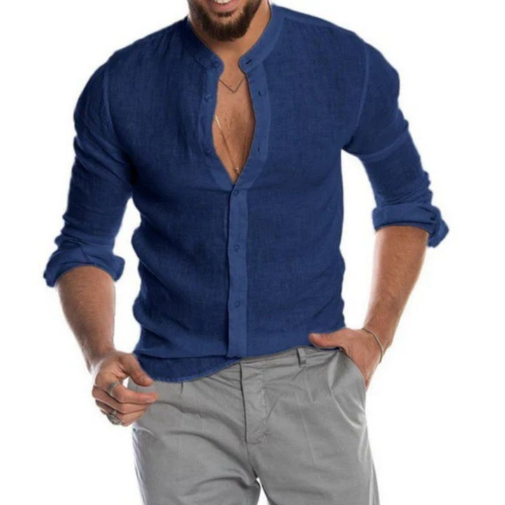 Mann in dunkelblauem Leinenhemd mit Stehkragen, graue Hose, lässiger Stil.