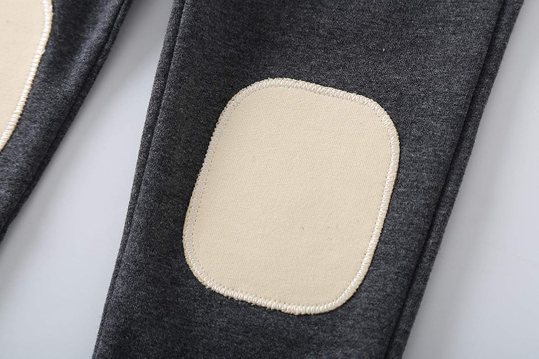 Dunkelgraue Kinderhose mit beigen Knieflicken, Baumwolle, bequem, langlebig.