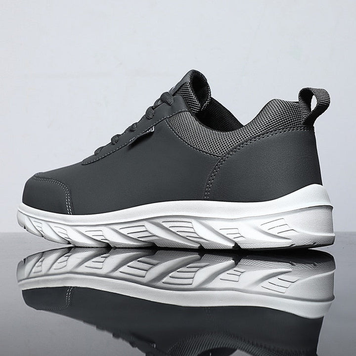 Grauer Sneaker aus Leder, rutschfeste Sohle, Herrenmode, sportlich, bequem, modern.