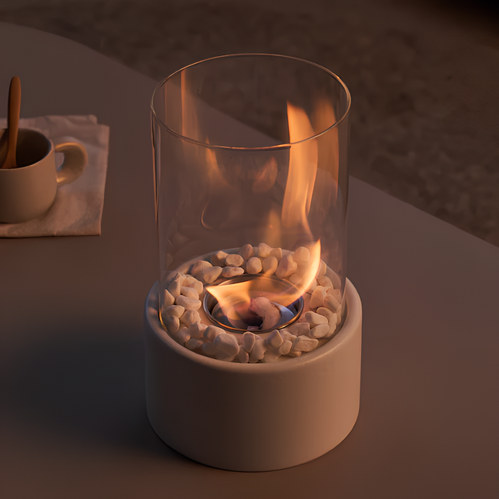 Glas-Feuerstelle mit weißen Steinen, Tischdekoration, modernes Design, gemütliche Atmosphäre.