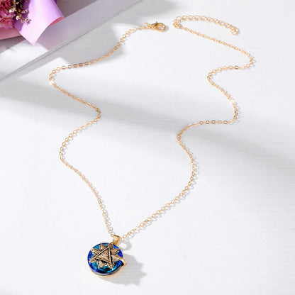 Goldene Halskette mit blauem, rundem Anhänger und Sternmotiv auf weißem Hintergrund.