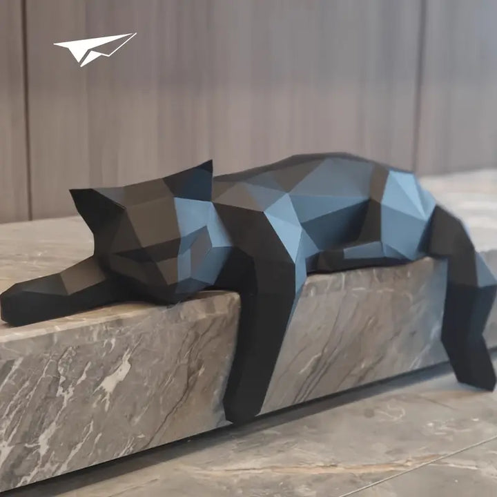 Schwarze geometrische Katzenfigur aus Harz, modern, dekorativ, auf Marmorsockel liegend.