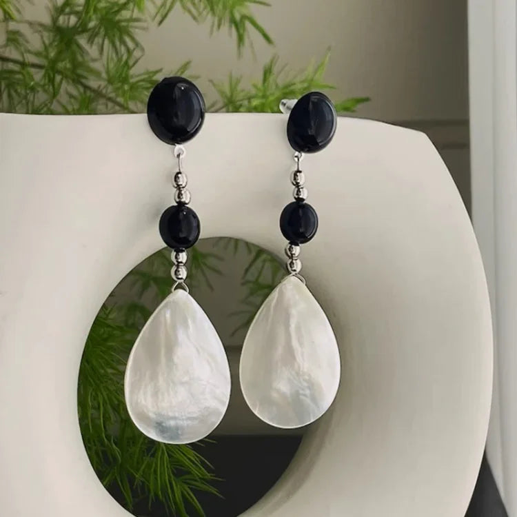 Schwarze und weiße Perlenohrringe mit Tropfenanhänger, eleganter Schmuck, Damenaccessoire.