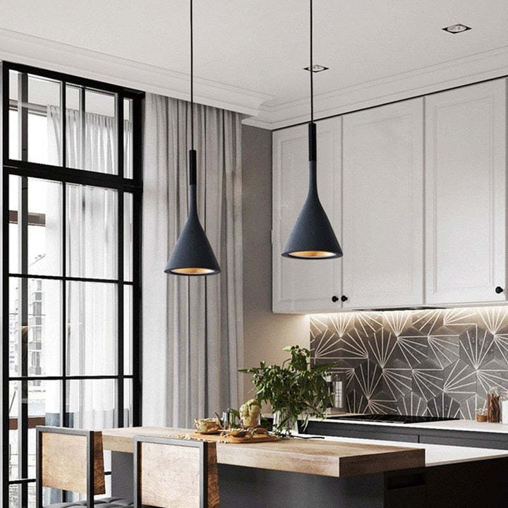 Moderne schwarze Pendelleuchten in stilvoller Küche mit weißen Schränken und geometrischem Backsplash.