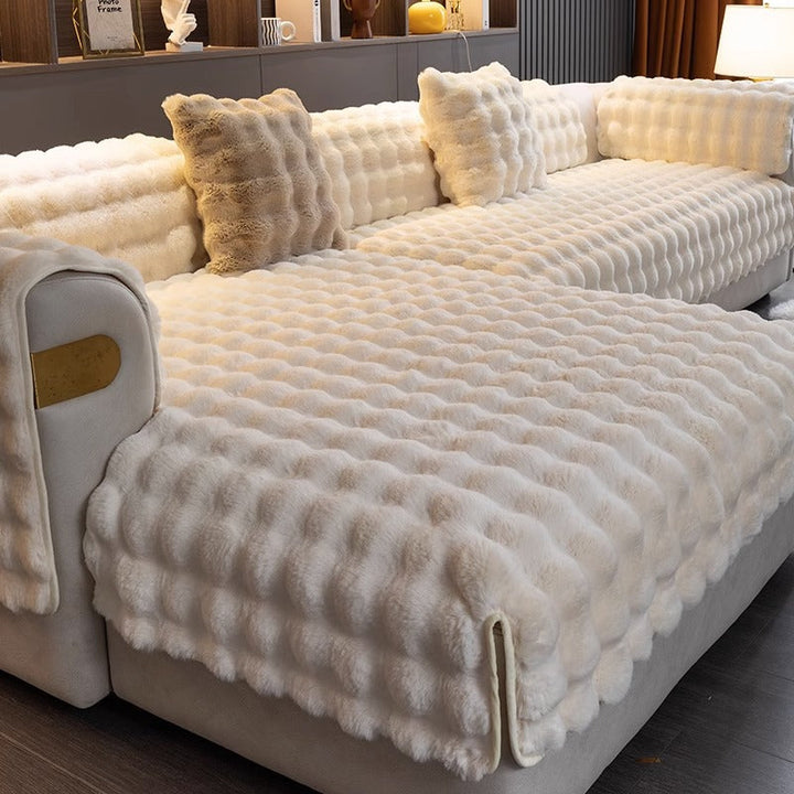 Luxuriöses cremefarbenes Kunstfell-Sofaüberwurf, weich, dekorativ, Wohnzimmer, modern.