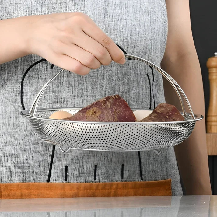 Person hält Edelstahl-Sieb mit Kartoffeln, Küchengerät, Abtropfsieb, Gemüse, Kochen.