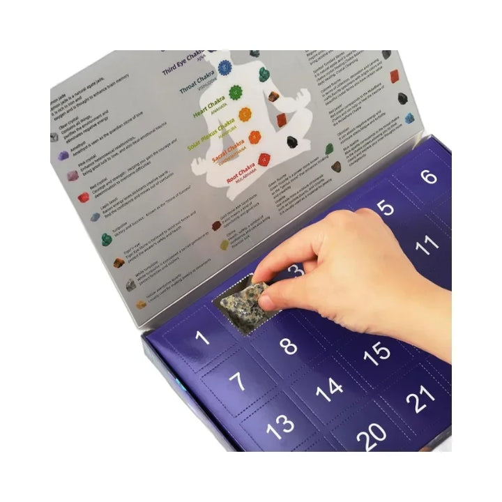 Hand öffnet Adventskalender mit Edelsteinen, lila Box, 24 Türchen, Geschenkidee, spirituell.