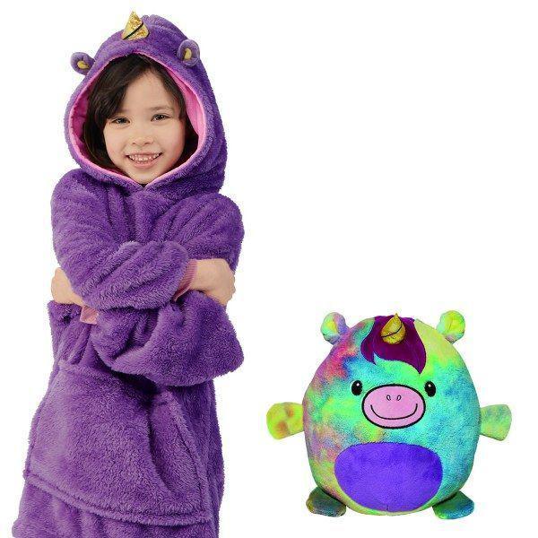 Mädchen im lila Einhorn-Kapuzenpullover neben buntem Einhorn-Plüschtier.