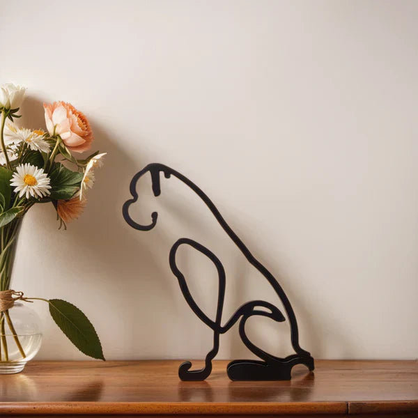 Schwarze Boxer-Skulptur aus Metall auf Holzregal neben Blumenstrauß in Vase.