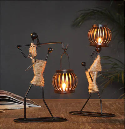 Zwei schwarze Metallfiguren mit Laternen, dekorative Tischlampen, rustikales Design.