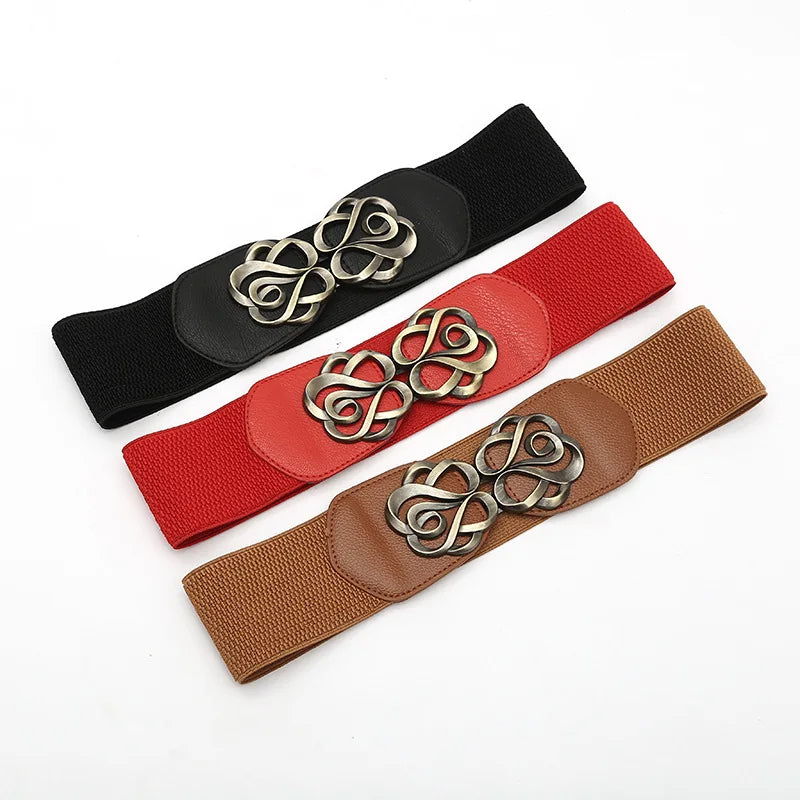 Drei elastische Gürtel in Schwarz, Rot und Braun mit dekorativer Metallschnalle.