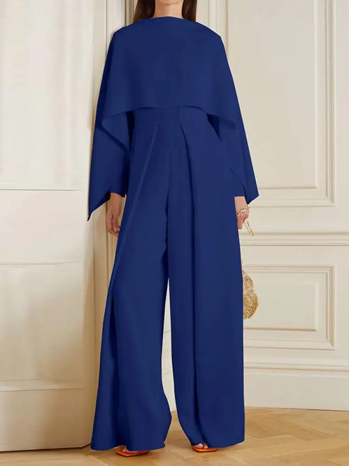 Frau in blauem, elegantem Jumpsuit mit weitem Bein und langen Ärmeln, modisch, Frühling 2024.