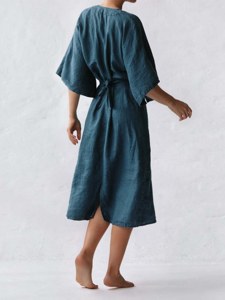 Frau in blauem, lockerem Sommerkleid, knielang, Kurzarm, Vintage-Stil, Rückansicht.