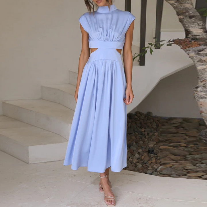 Frau in hellblauem, ärmellosem Sommerkleid mit Stehkragen und Cut-Out-Design auf Treppe.